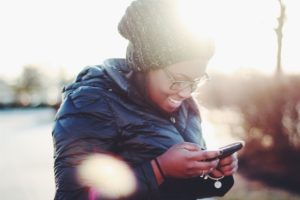 a woman looks down at her phone