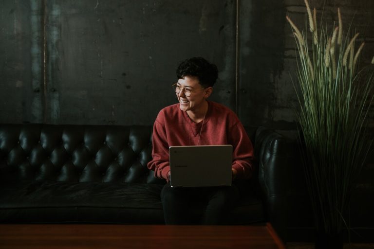 image of woman smiling and working on laptop