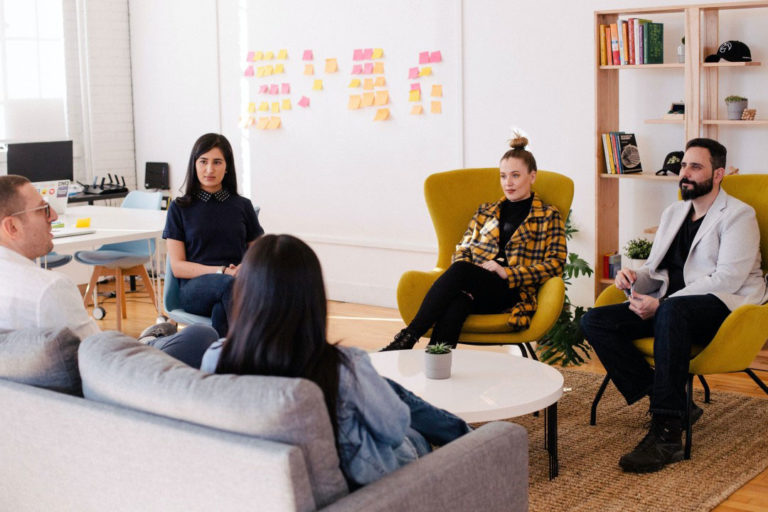 group of diverse young adults, sitting in a circle having a conversation