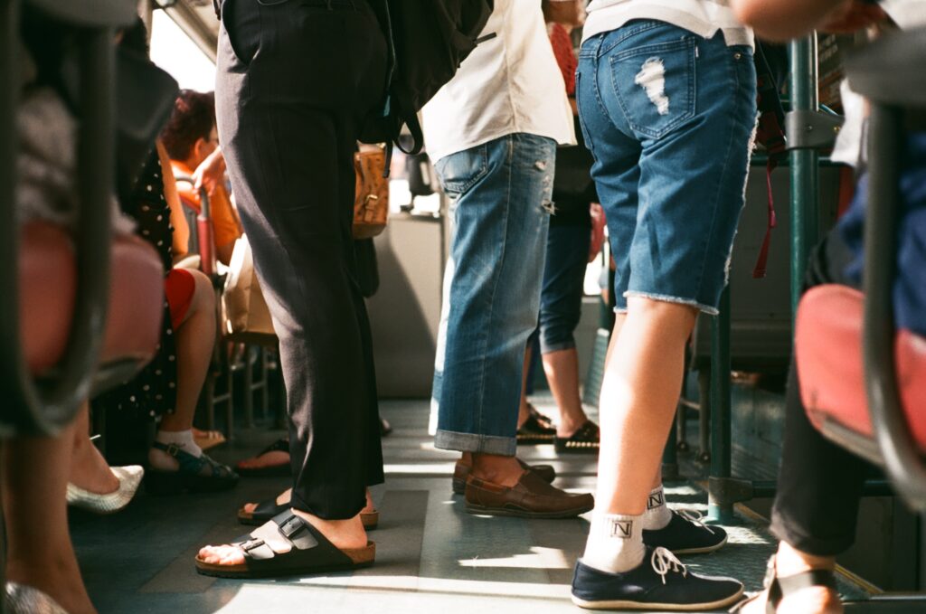 diverse people stand on a bus