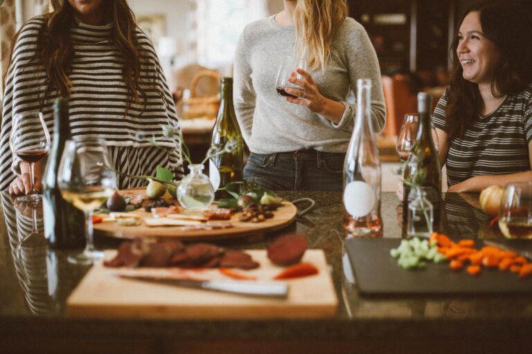 women stand at a table with beverages