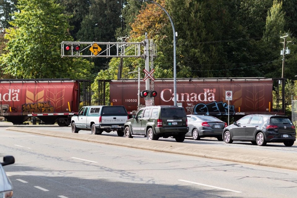 cars stop at a rail crossing