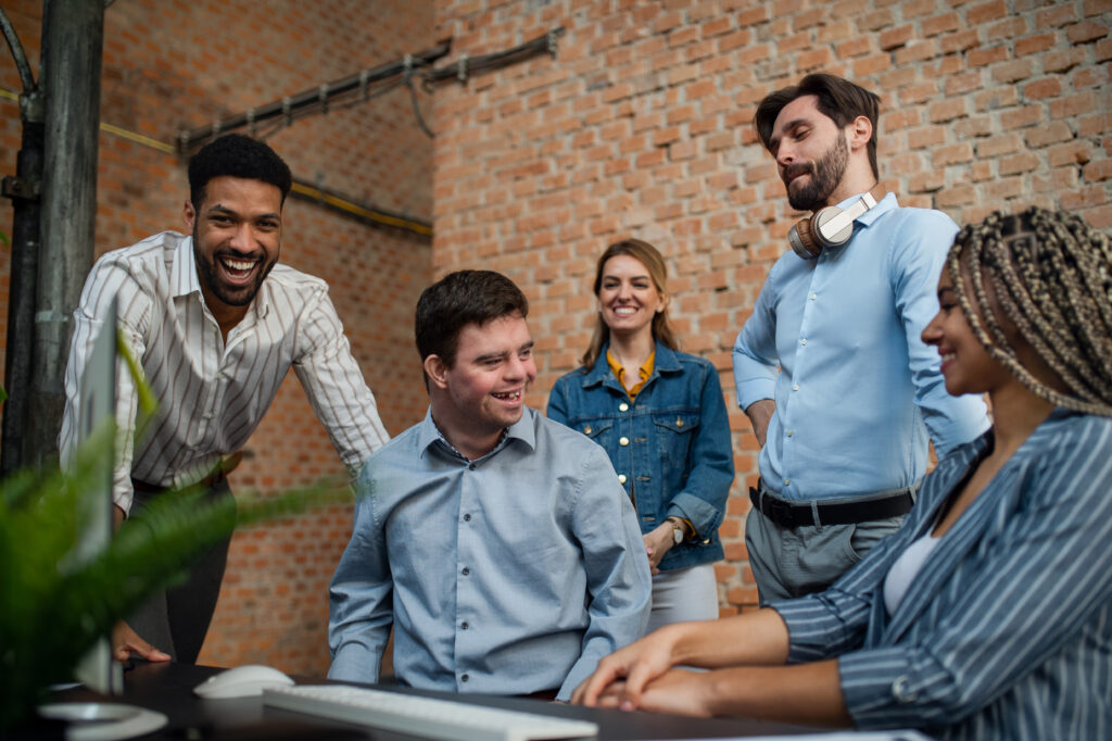 Cheerful young businesspeople having fun in a office, social inclusion and cooperation concept