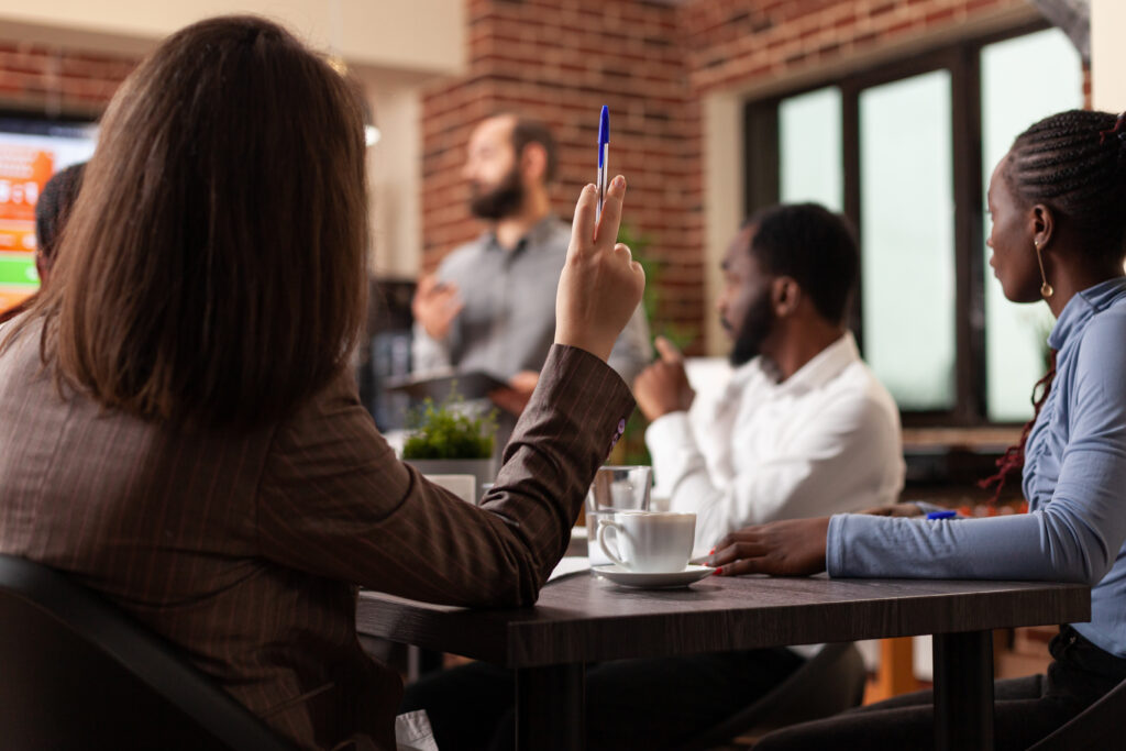 a woman raises her hand at work