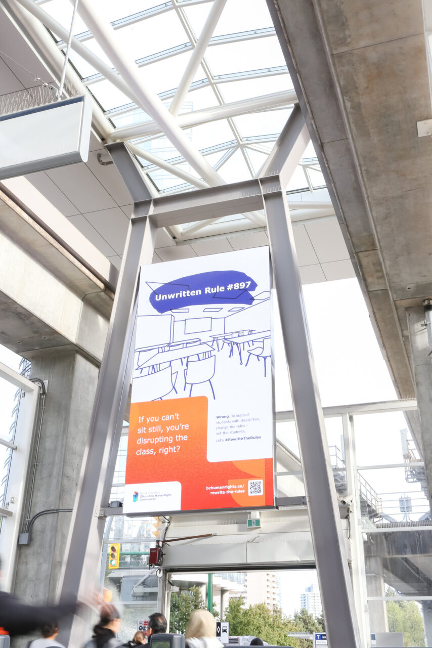 a large digital billboard hangs in a transit station