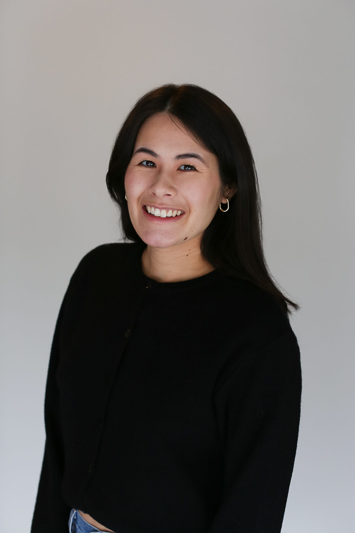 headshot of a woman with shoulder-length brown hair and a black sweater