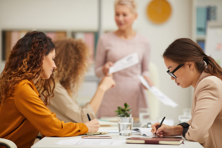 a group of women listening and reading in a meeting