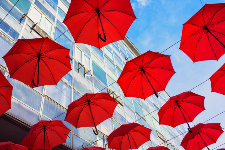 Red umbrella installation under blue sky