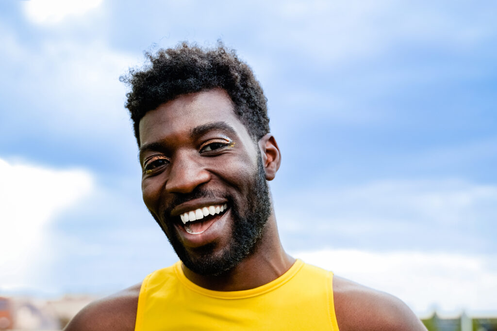 Queer black man smiles